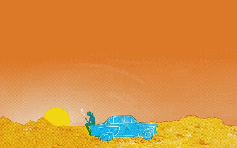 person sitting in desert at sunset