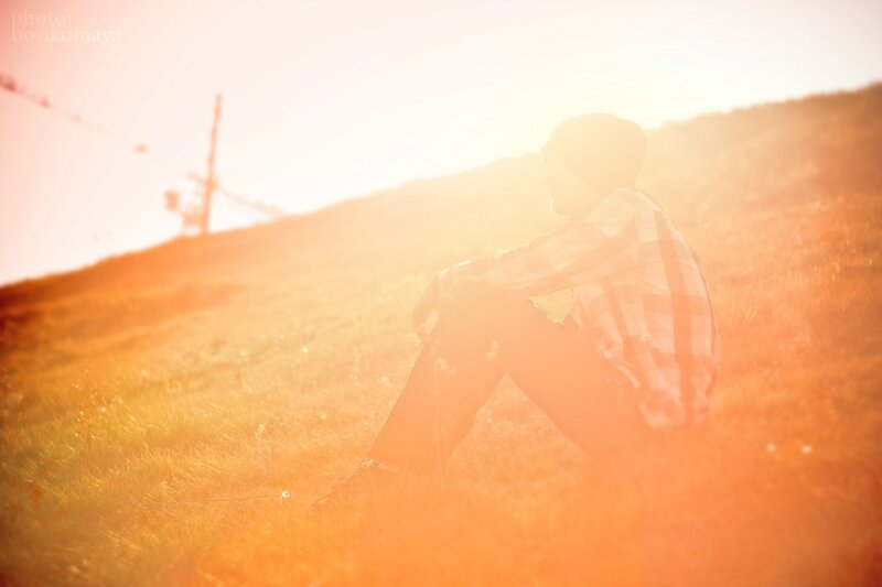 person sitting in field at sunset