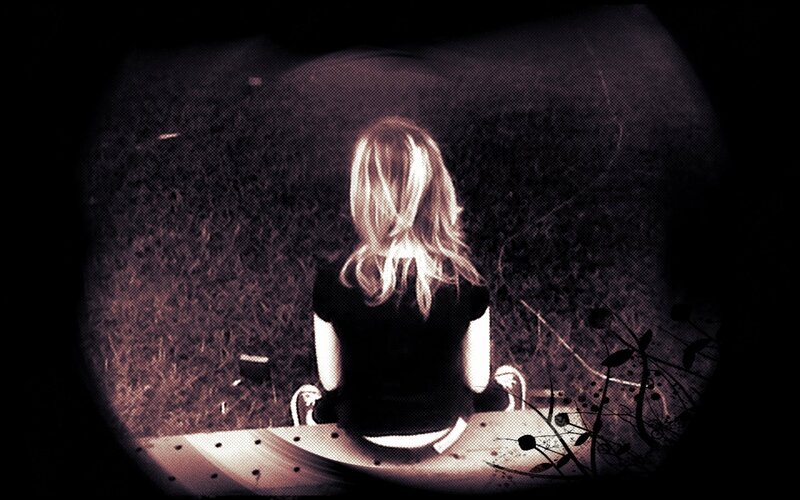 person sitting on a bench at night