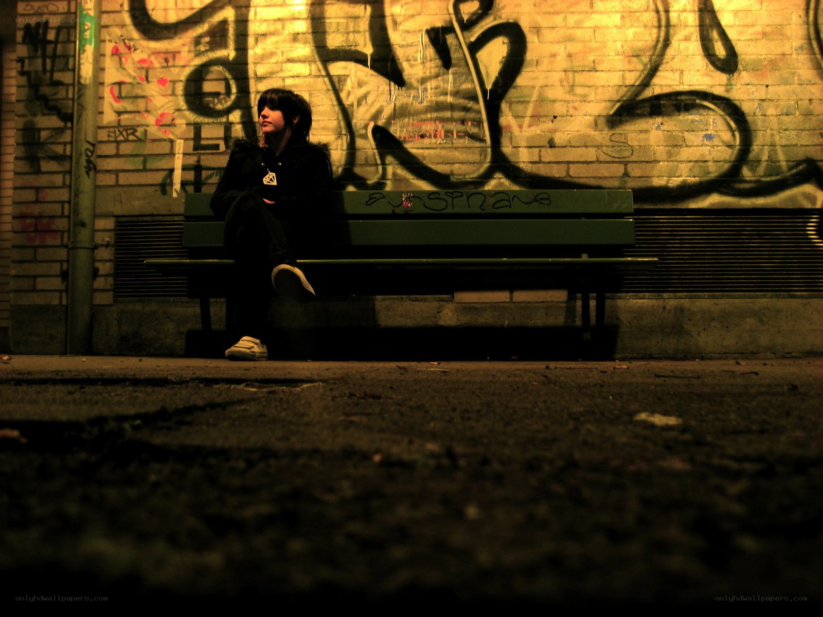 person sitting on a bench at night
