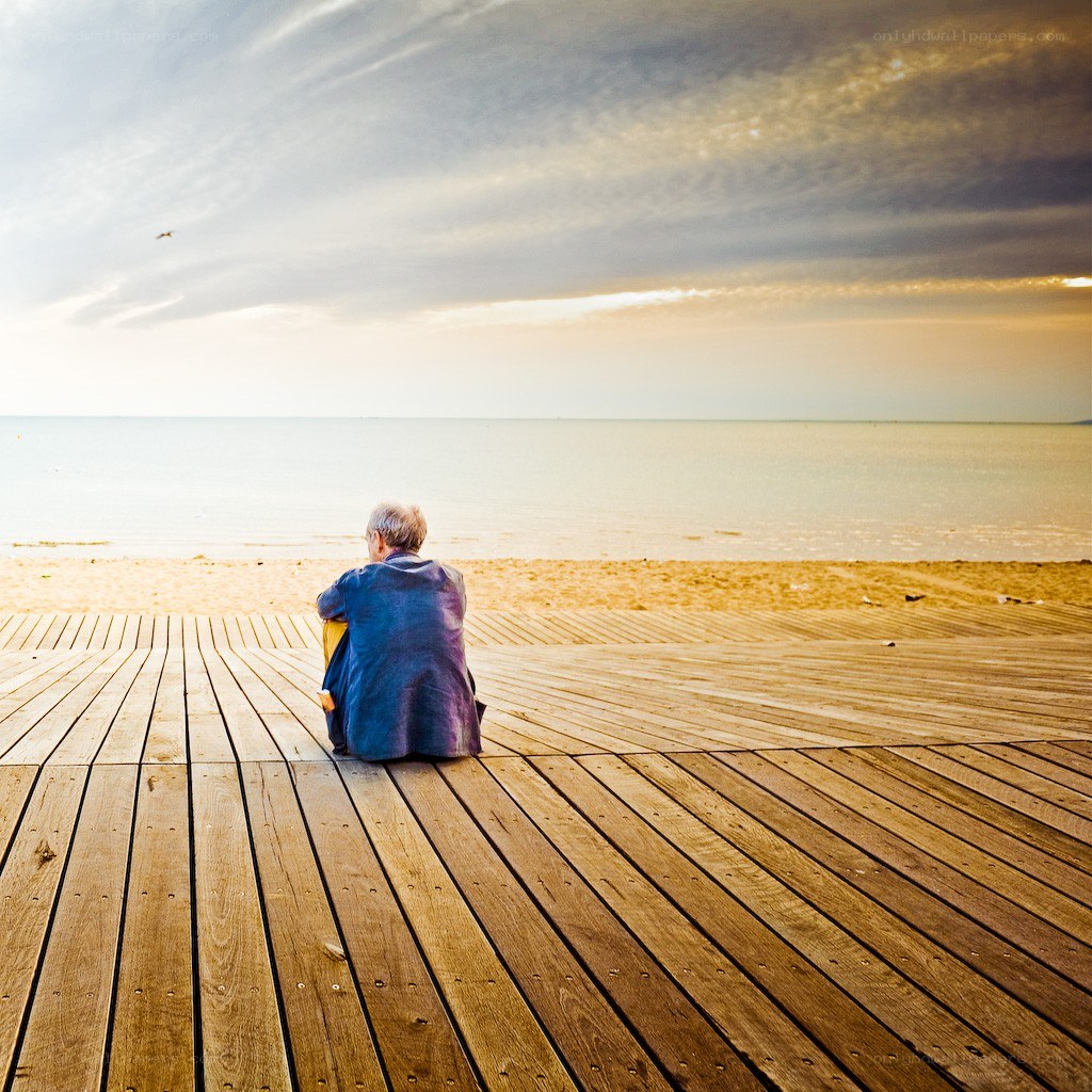 Person sitting on a boardwalk