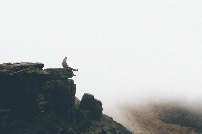 person sitting on a cliff