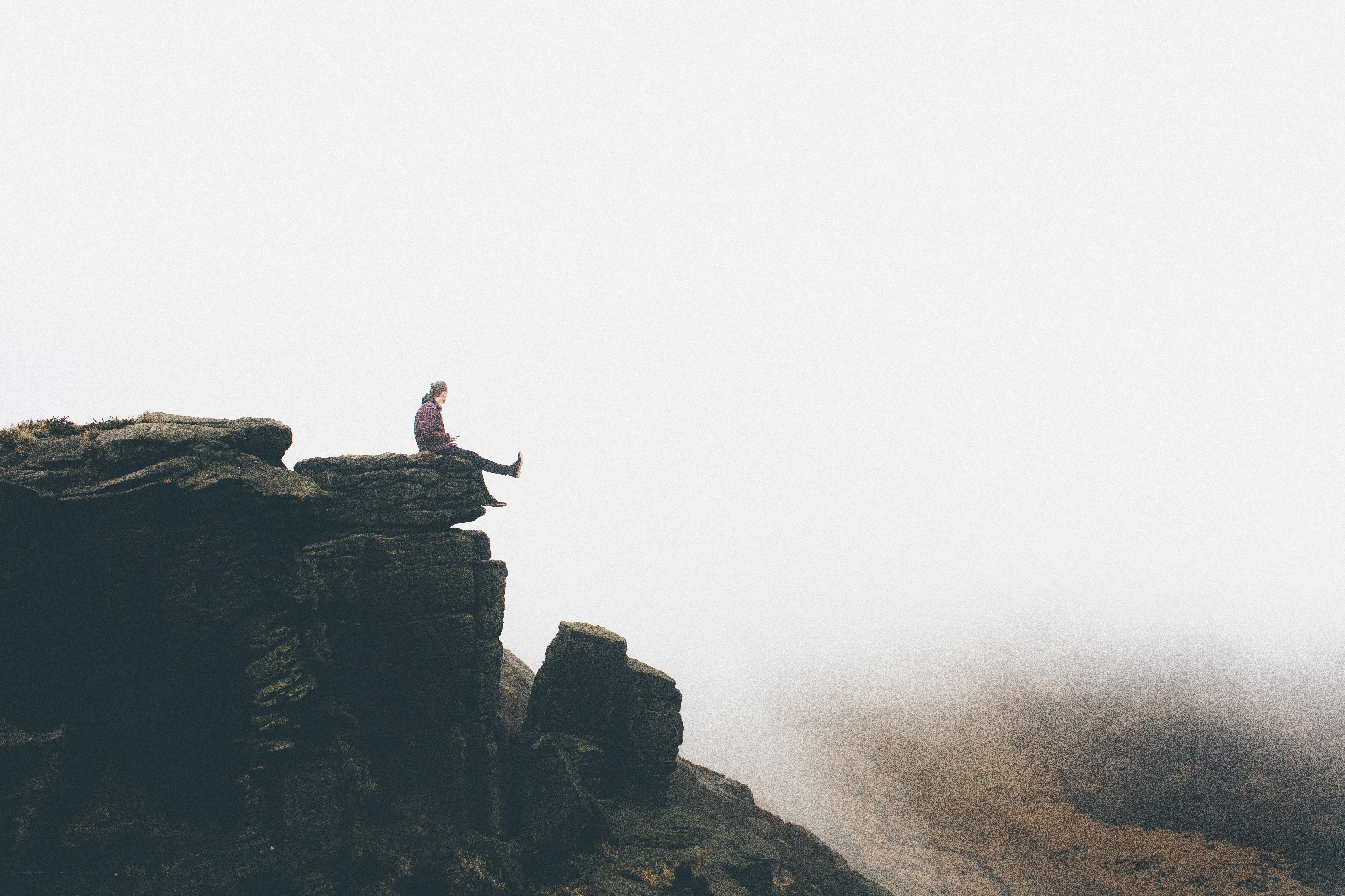 person sitting on a cliff