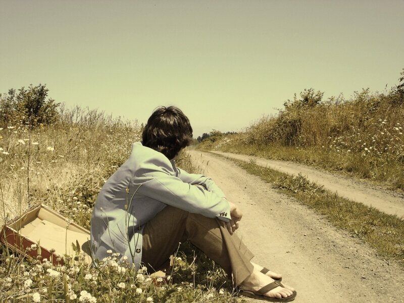 Person sitting on a dirt road