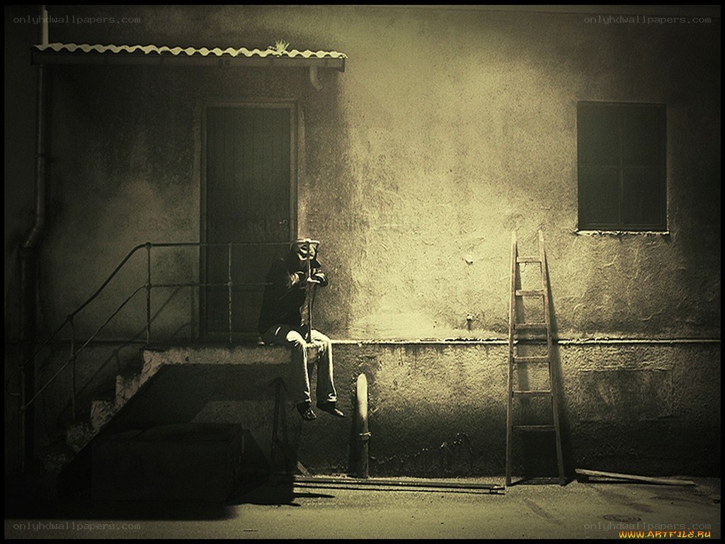 person sitting on a ledge at night