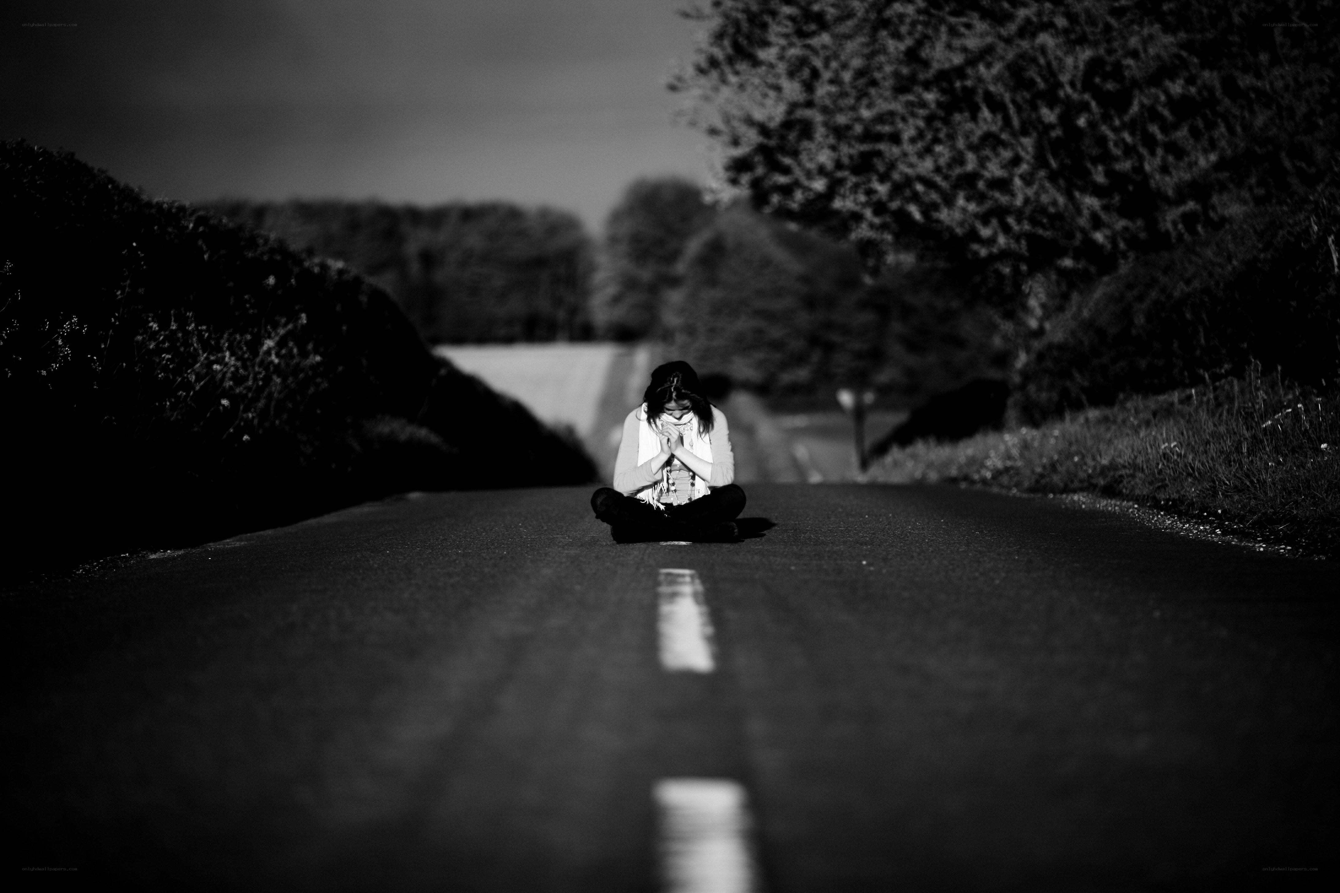 Person sitting on a road