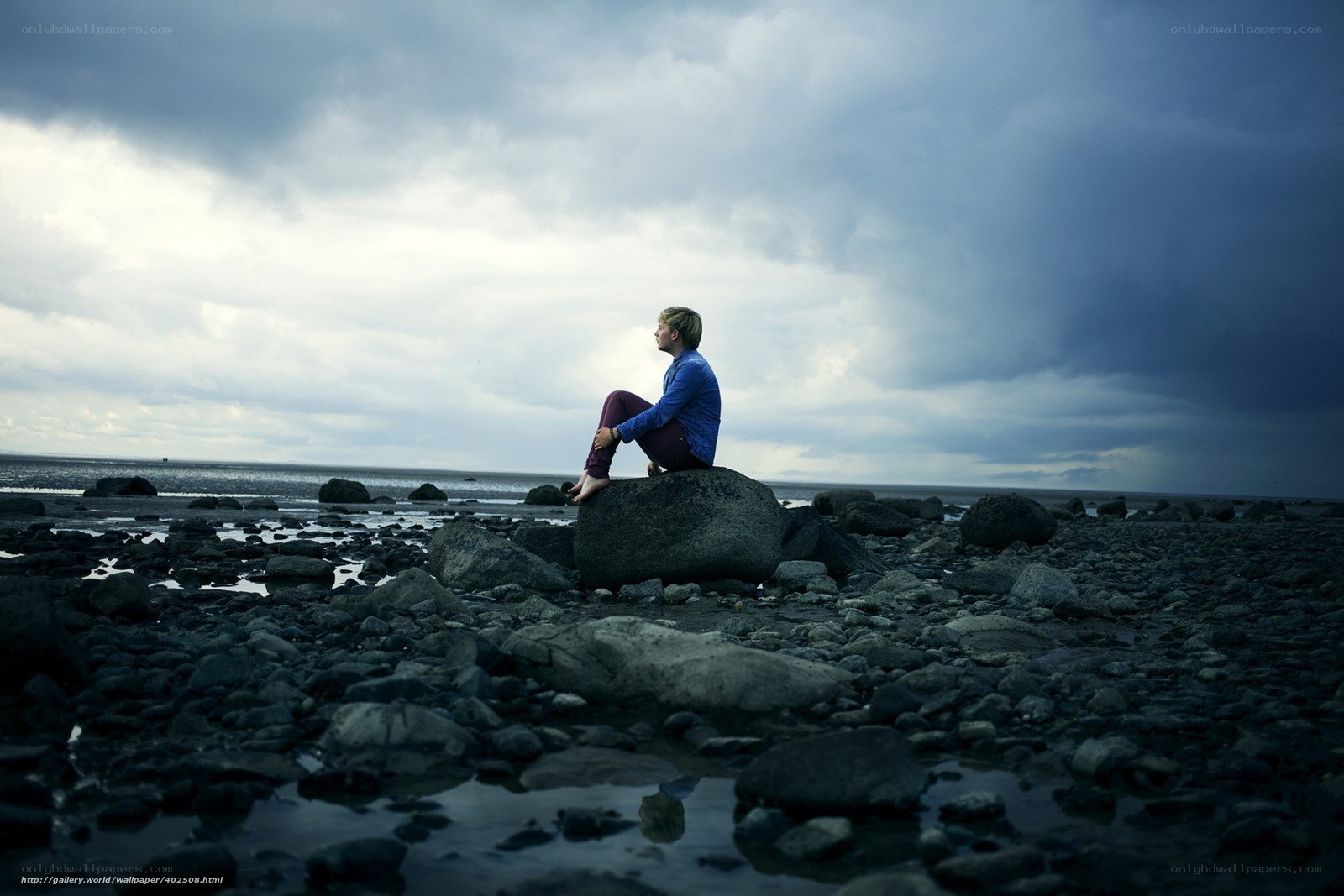 Person sitting on a rock at the beach