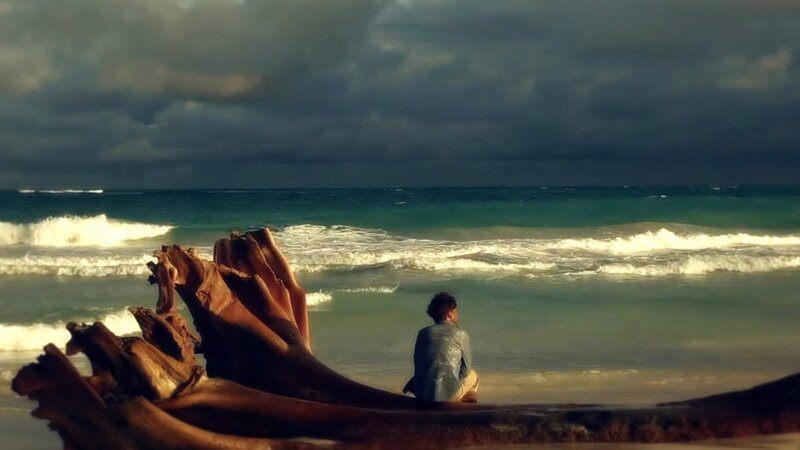 Person Sitting on Beach — Blue, Dramatic, Afternoon, Photograph