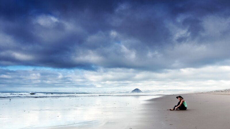 Person Sitting on Beach — Blue, Dramatic, Afternoon