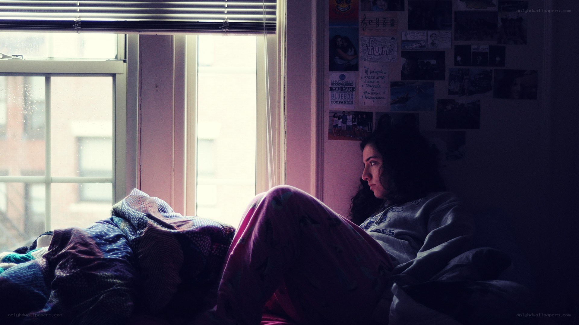 person sitting on bed by window