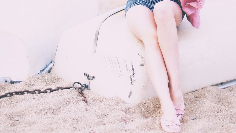 person sitting on boat in sand