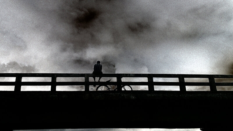 Person Sitting on Bridge