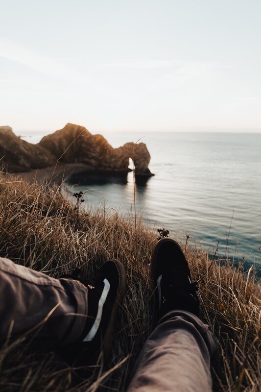 Person Sitting on Cliff — Brown, Serene, Sunset