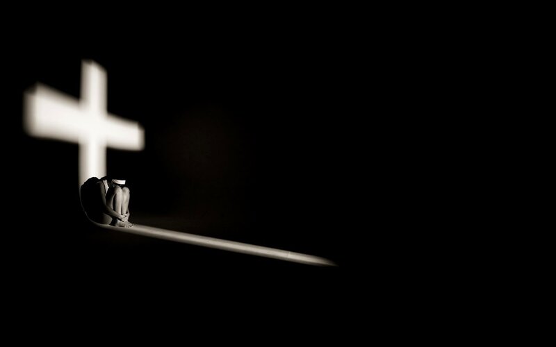 Person Sitting on Cross