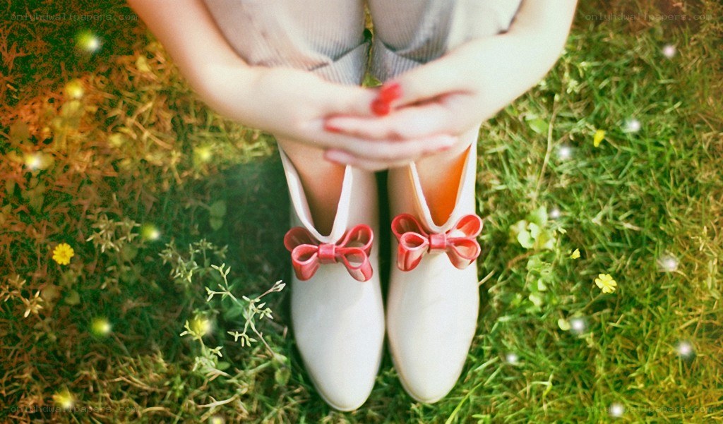person sitting on grass with shoes