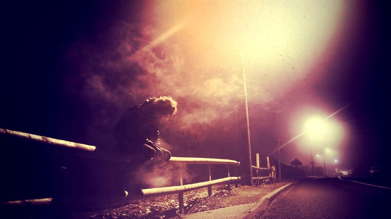 Person Sitting on Guardrail