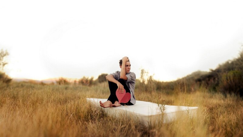 person sitting on mattress in field