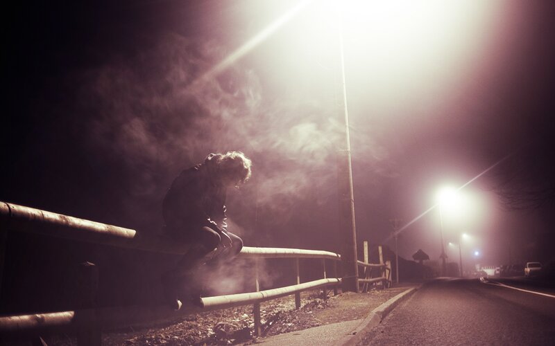 Person Sitting on Rail