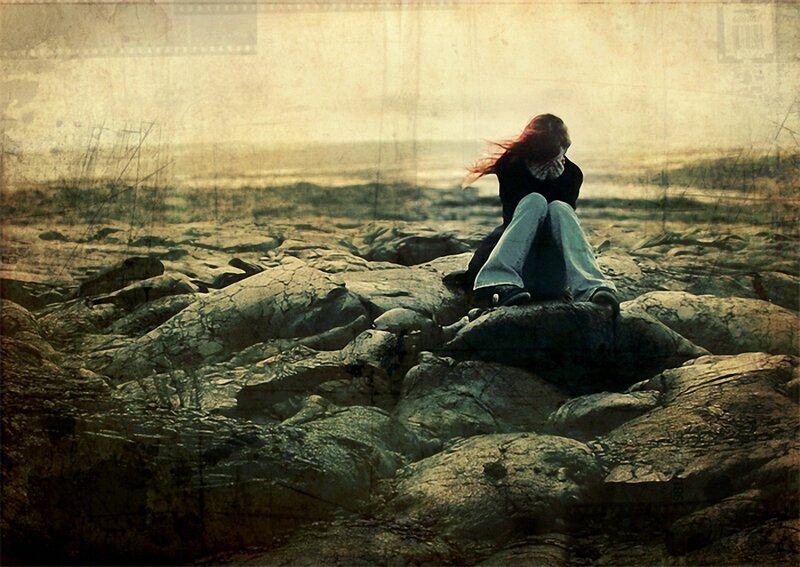 person sitting on rocks at sunset