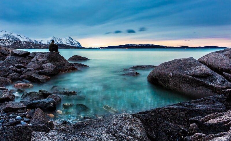 Person Sitting on Rocks — Blue