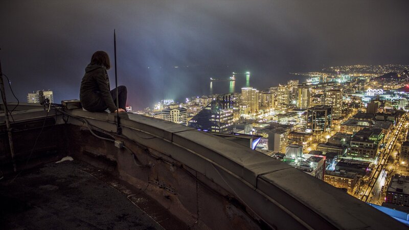 Person Sitting on Rooftop — Black, Dramatic, Night, Photograph, Cityscape, Buildings