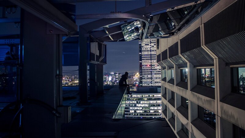 Person Sitting on Rooftop — Black, Dramatic, Night, Photograph