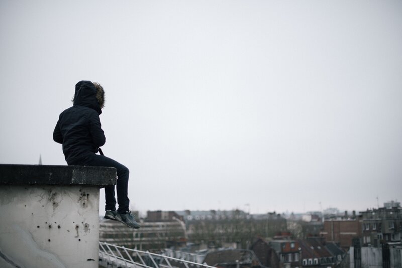 person sitting on rooftop edge