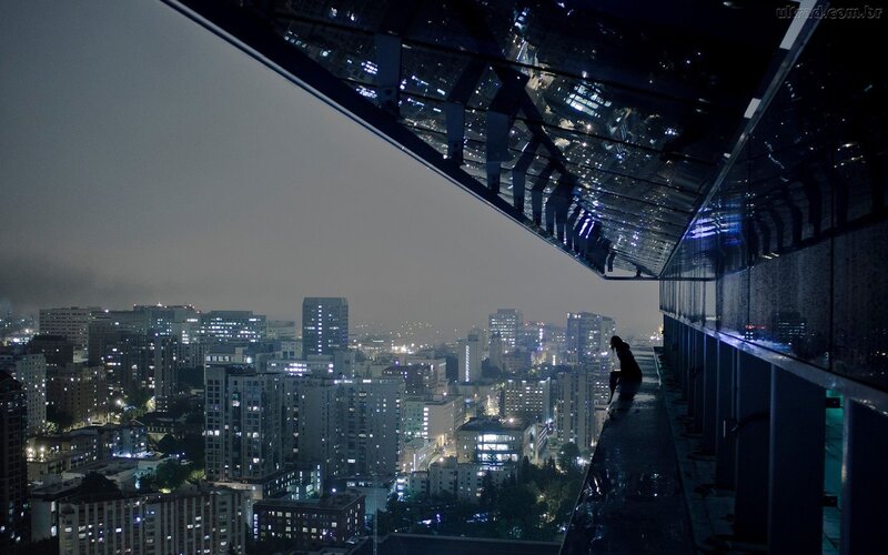 Person Sitting on Rooftop — Night