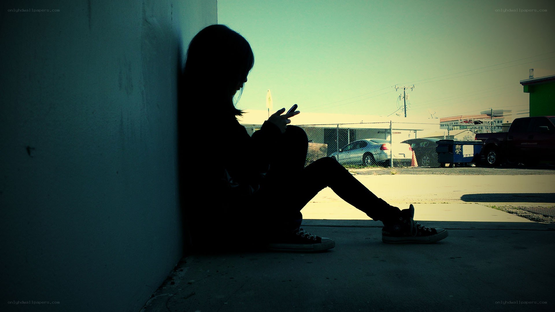 person sitting on sidewalk