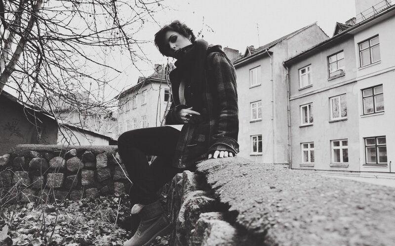 person sitting on stone wall
