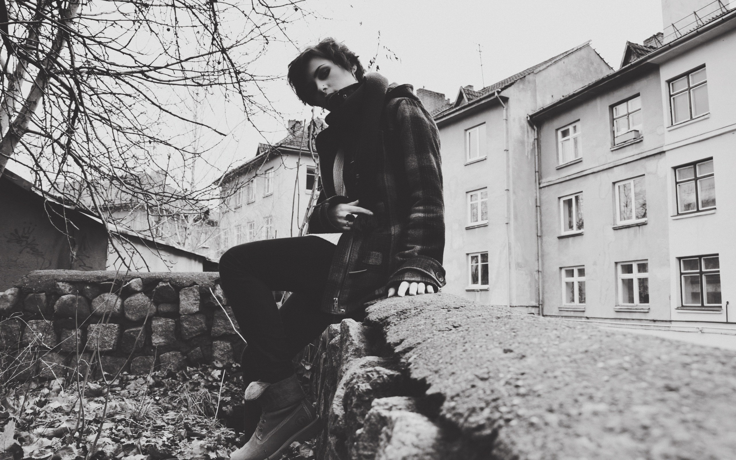 person sitting on stone wall