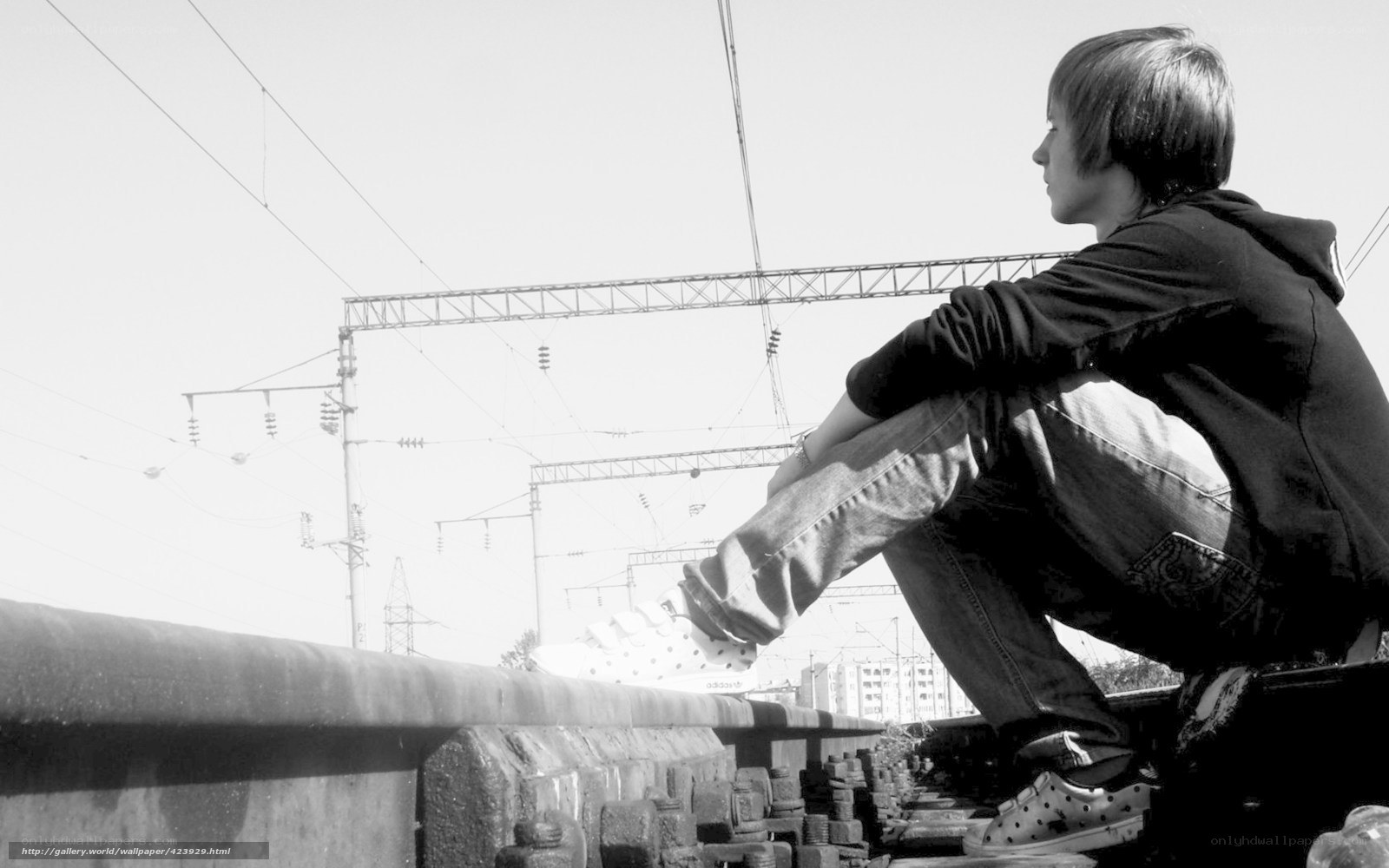 person sitting on train tracks
