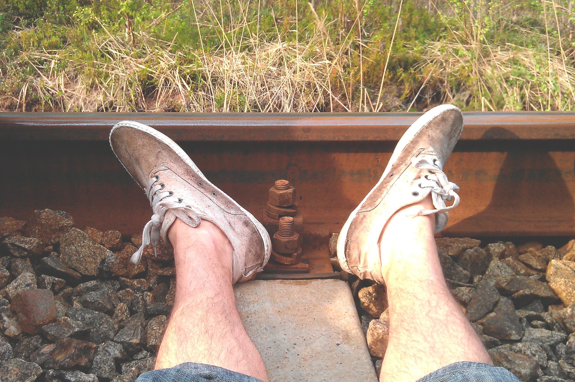 Person sitting on train tracks