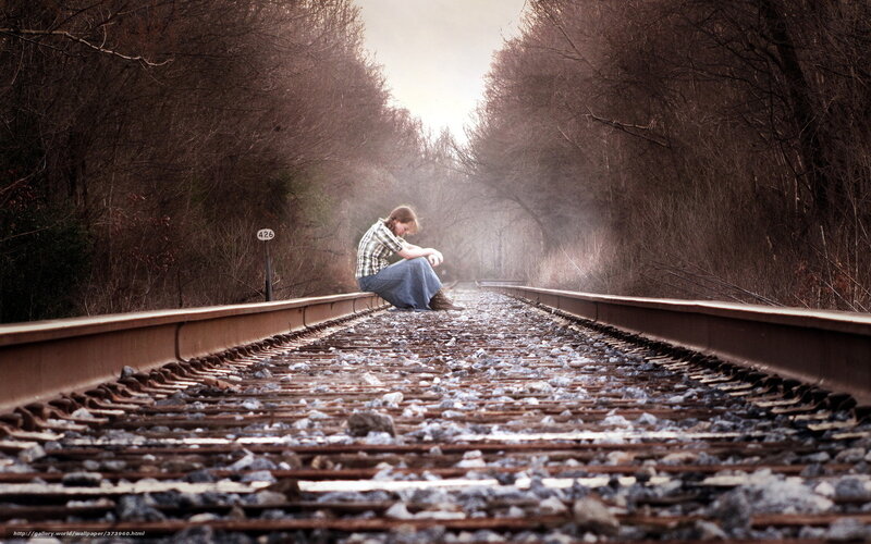 Person Sitting on Train Tracks — Brown
