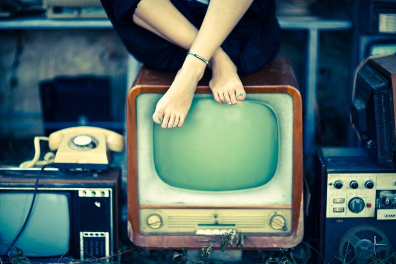 person sitting on vintage TV