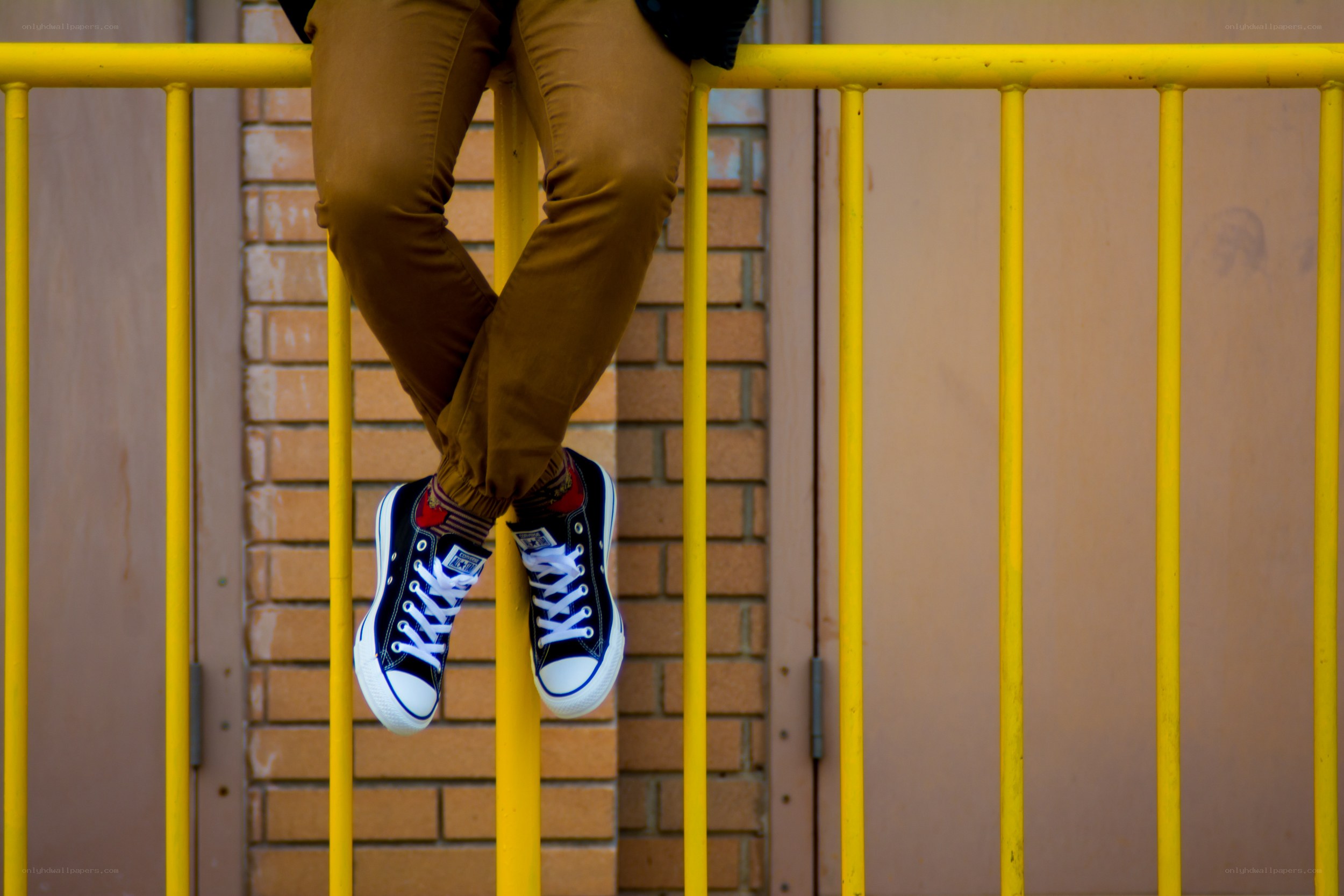 person sitting on yellow railing