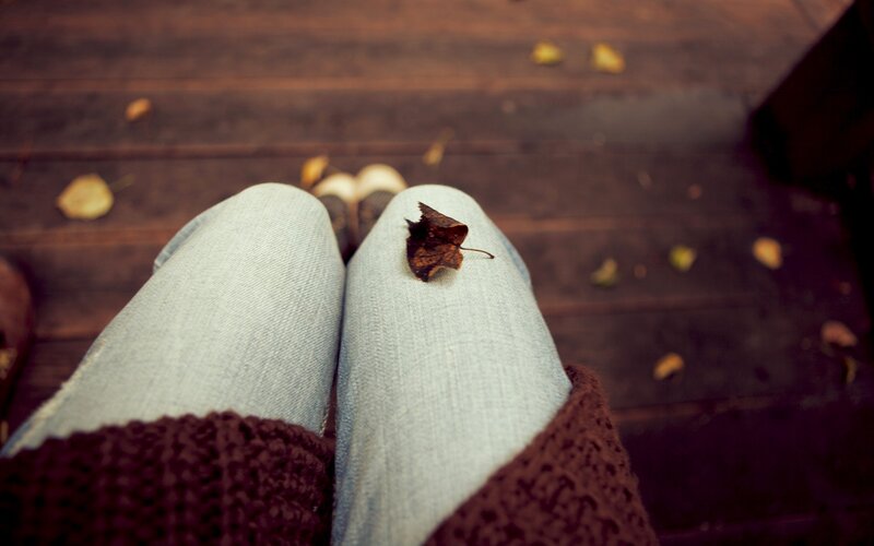 person sitting with leaf on knee