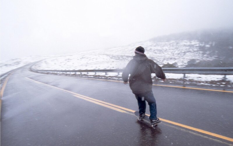 person skateboarding on snowy road