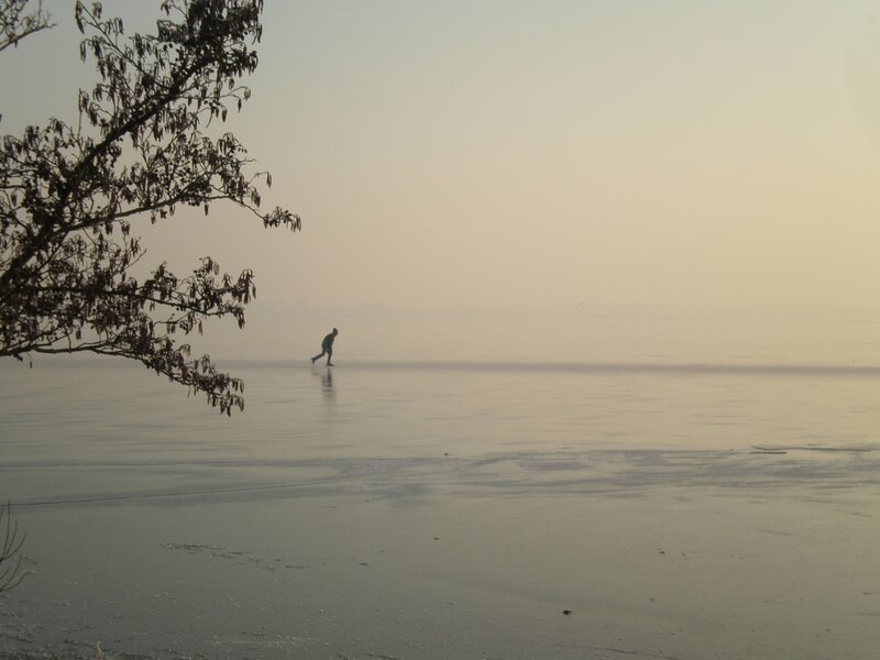 Person skating on frozen lake