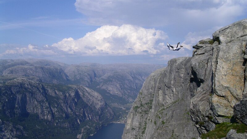 person skydiving from cliff