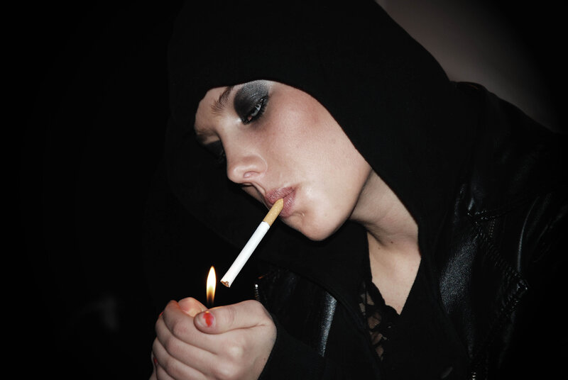 person smoking in black hoodie