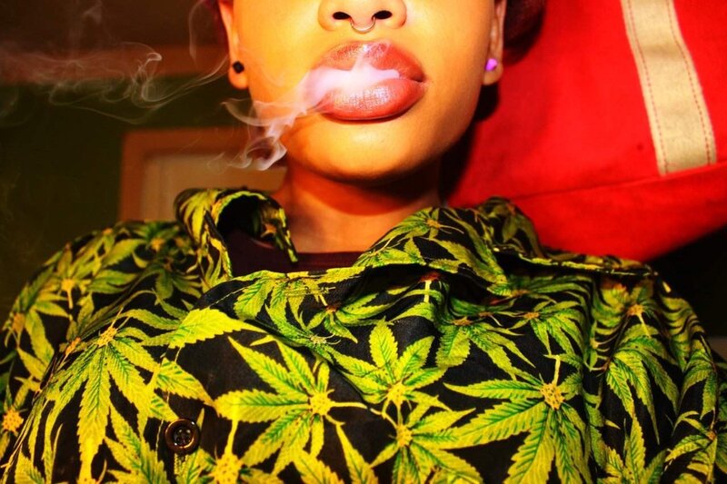 person smoking with marijuana leaf shirt