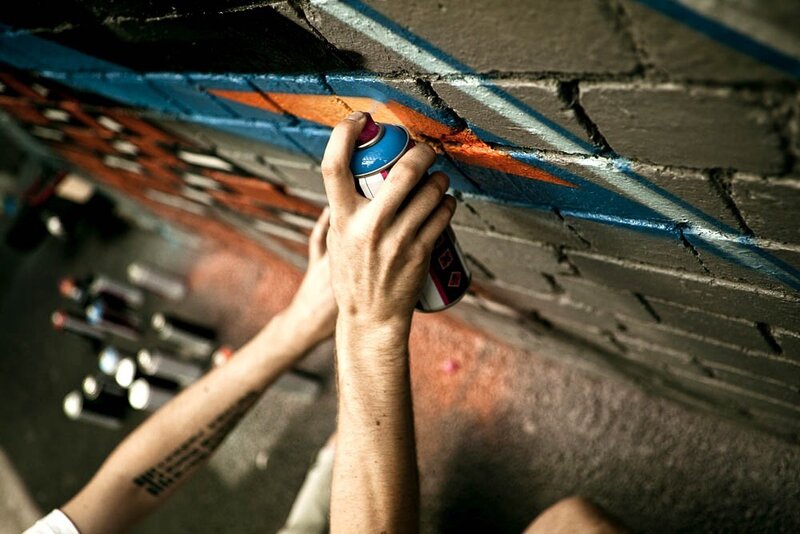 Person Spray Painting Wall — Blue, Dramatic