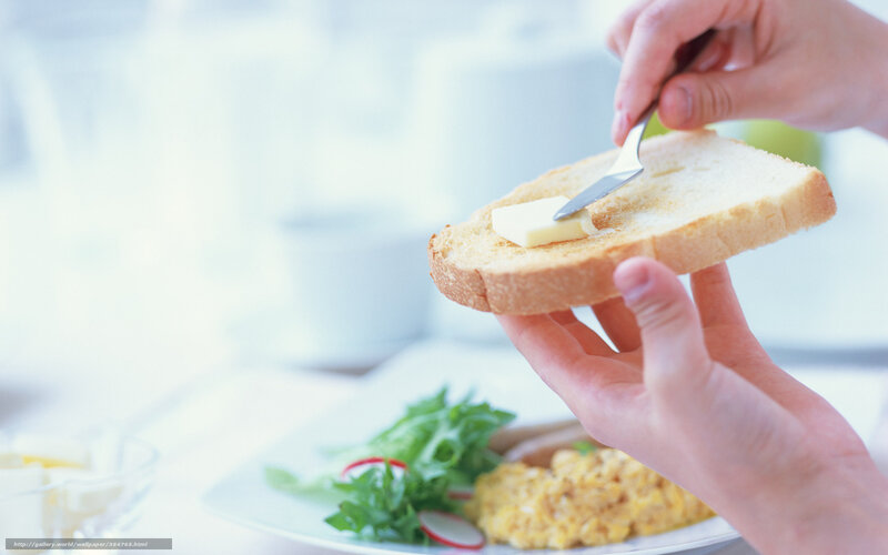 Person Spreading Butter on Bread
