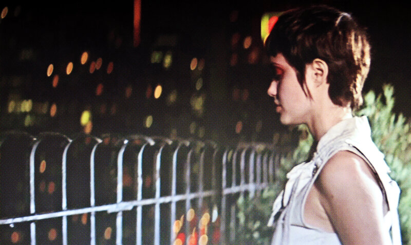 person standing by fence at night