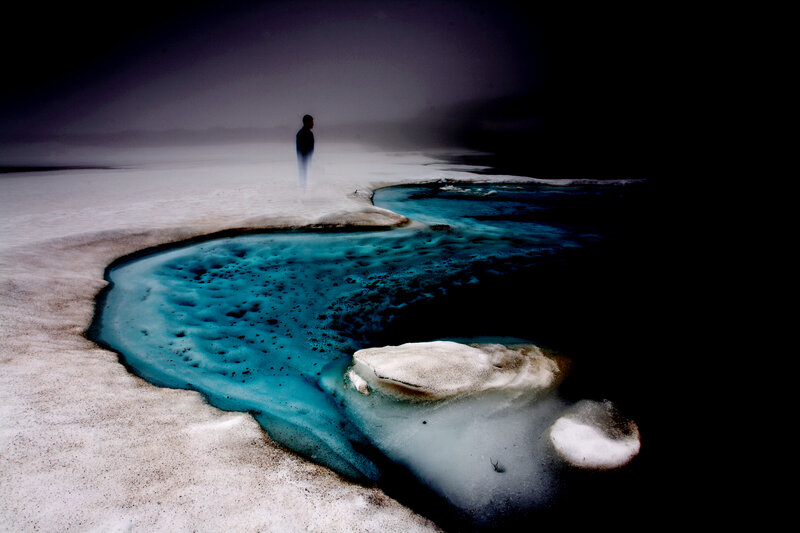 person standing by icy stream