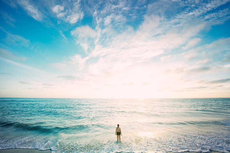 Person Standing in Ocean — Blue, Serene, Sunset