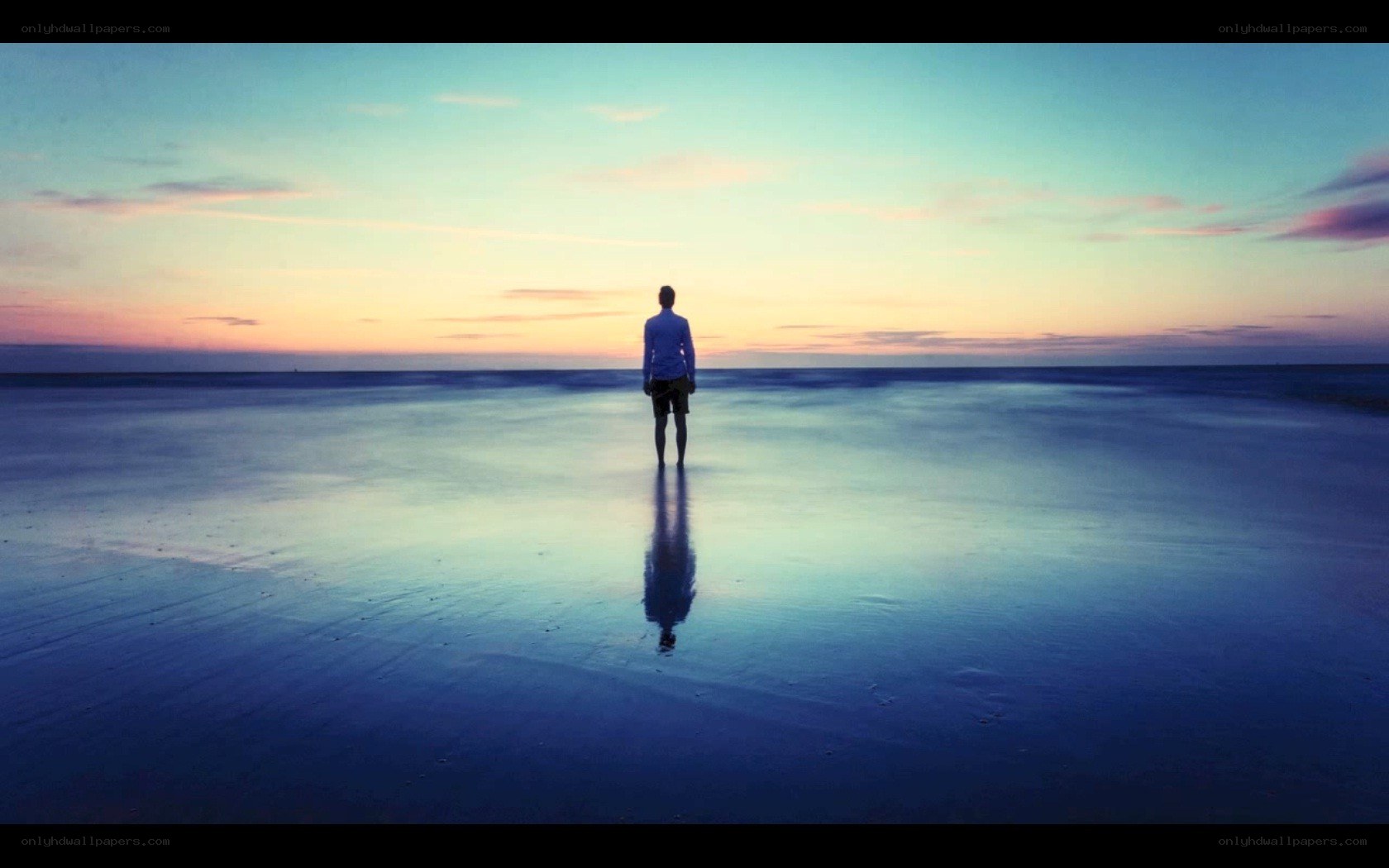 person standing on beach at sunset