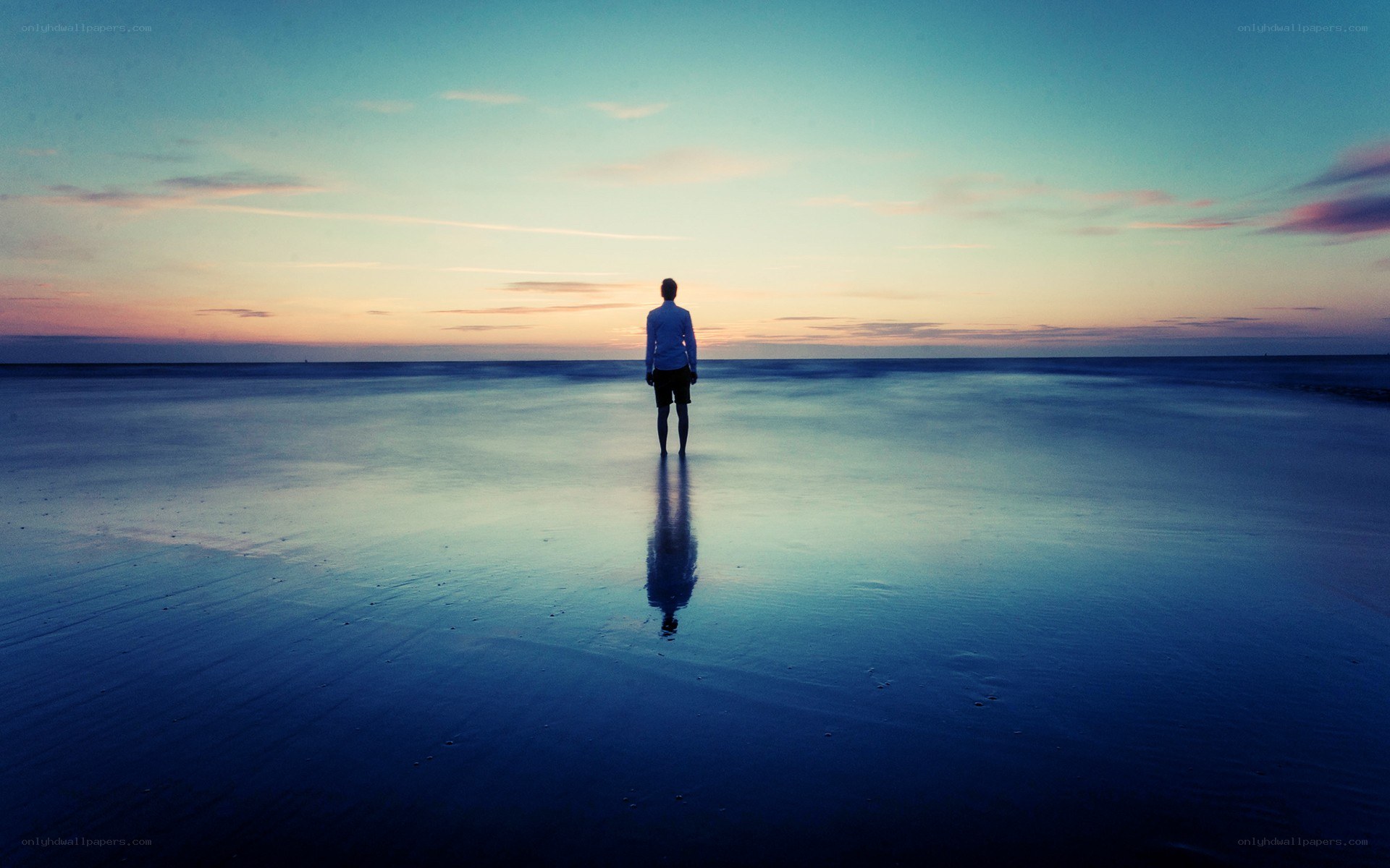 person standing on beach at sunset