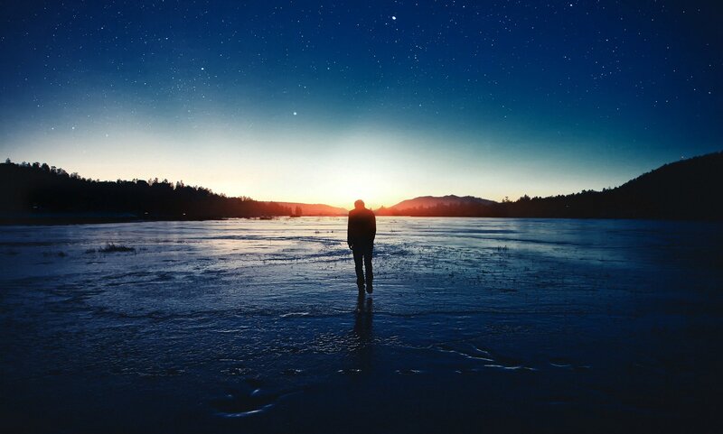 Person Standing on Frozen Lake